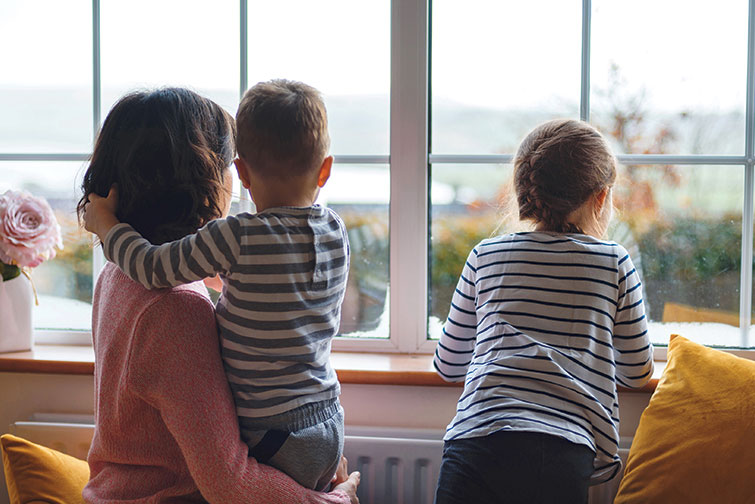 young-family-at-home-looking-out-window